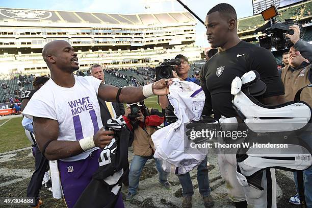 Running back Adrian Peterson of the Minnesota Vikings exchanges jerseys with outside linebacker Aldon Smith of the Oakland Raiders after the end of...