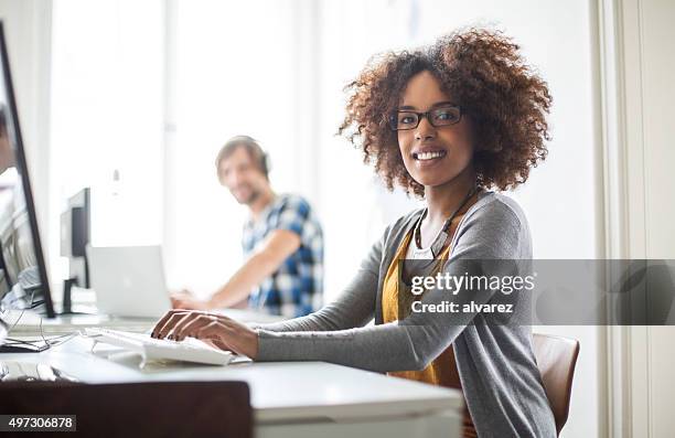 happy african woman working at her desk - apprentices stock pictures, royalty-free photos & images