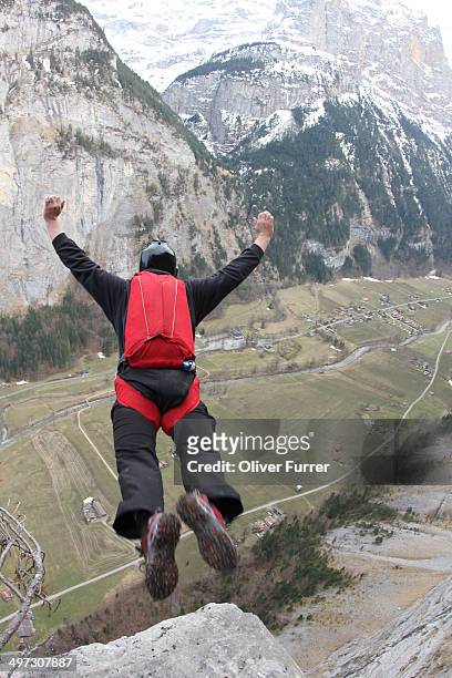 base jumper is exiting from a cliff - base jumping stock pictures, royalty-free photos & images