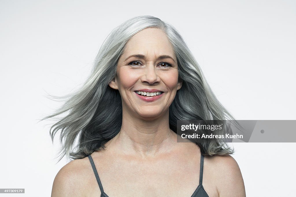 Mature woman with grey hair smiling, portrait.