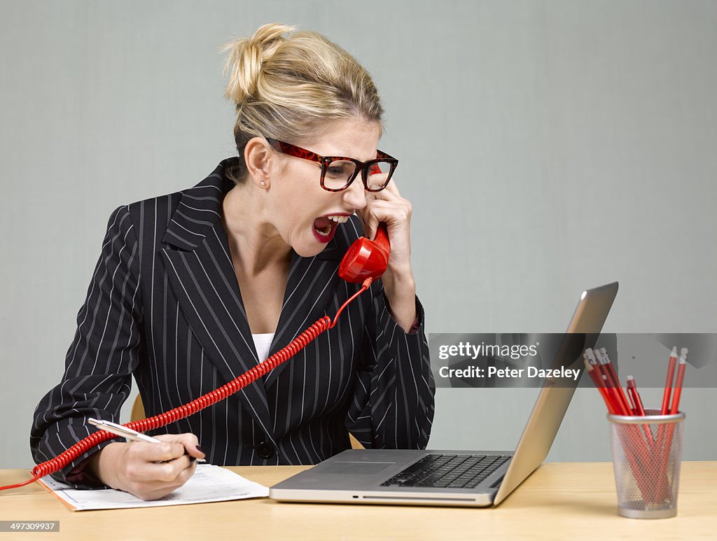 Angry businesswoman at desk