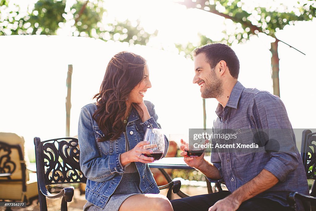 Couple enjoy glasses of wine at outdoor bar