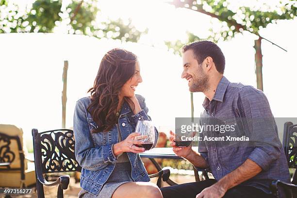 couple enjoy glasses of wine at outdoor bar - flirting imagens e fotografias de stock