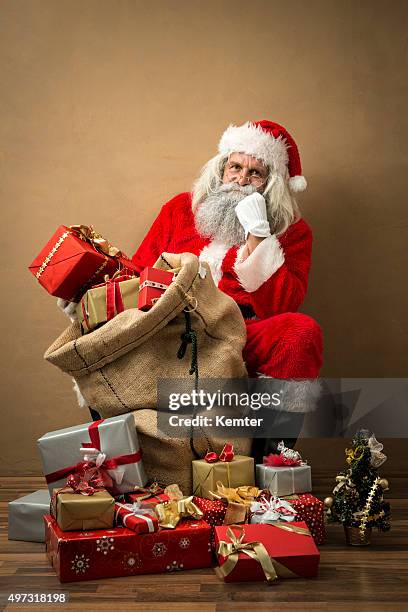 santa claus with many gifts in his bag - santa leaning stock pictures, royalty-free photos & images