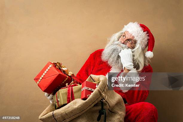 santa claus with many gifts in his bag - santa leaning stock pictures, royalty-free photos & images