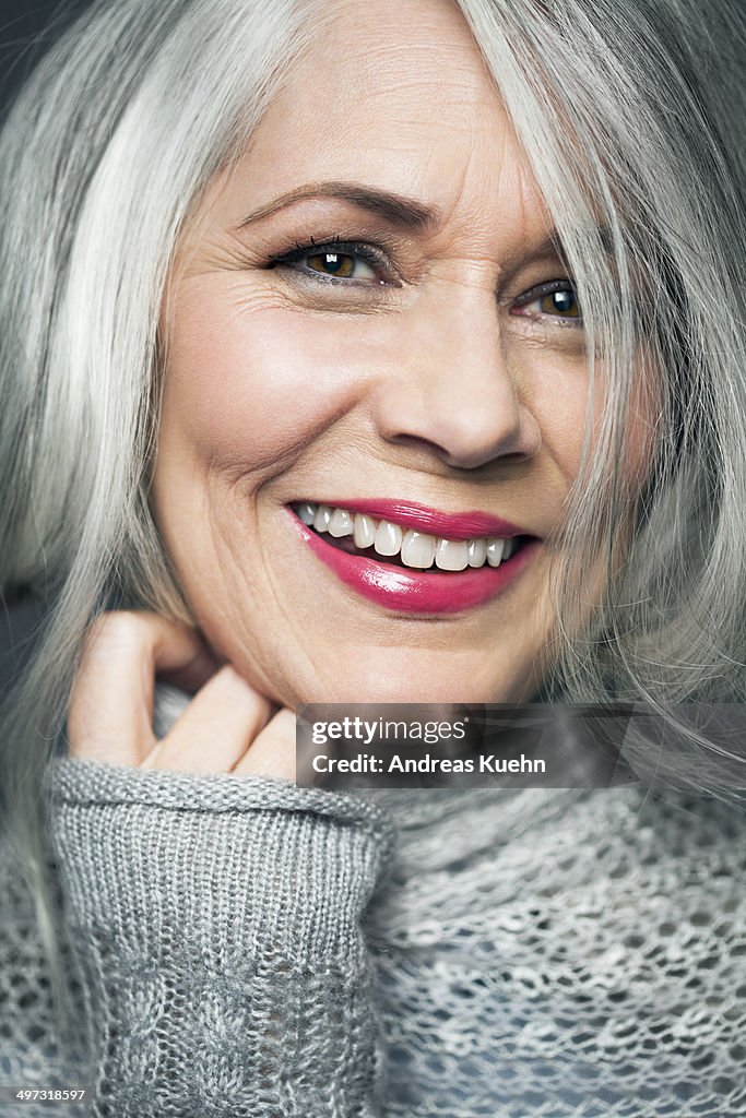 Tight portrait of grey haired lady with red lips.
