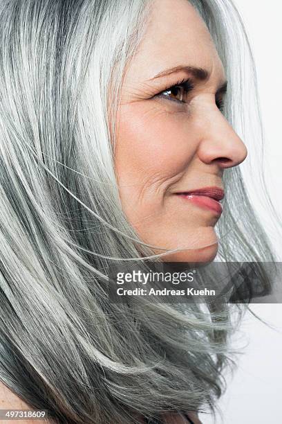 grey haired woman with a soft smile, profile. - woman smile stockfoto's en -beelden