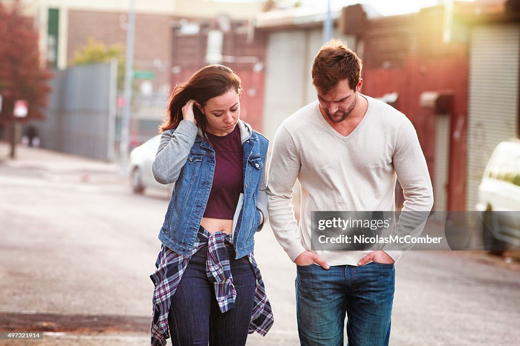 Young couple discussing relationship difficulties urban setting