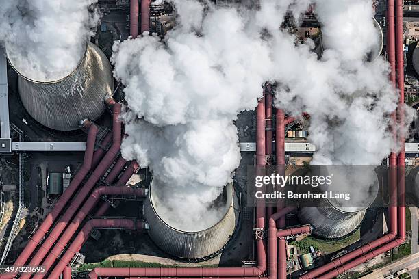 aerial view of steaming cooling towers - centrale elettrica foto e immagini stock