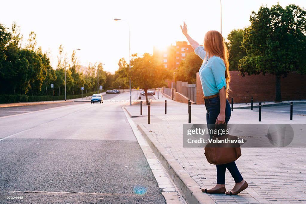 Blonde young woman on the street at sunset