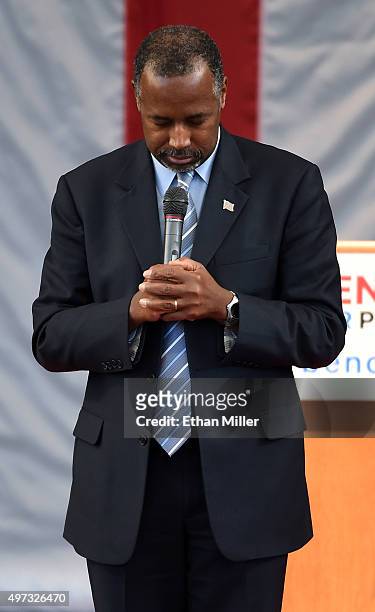 Republican presidential candidate Ben Carson bows his head at the beginning of a campaign rally at the Henderson Pavilion after asking for a moment...