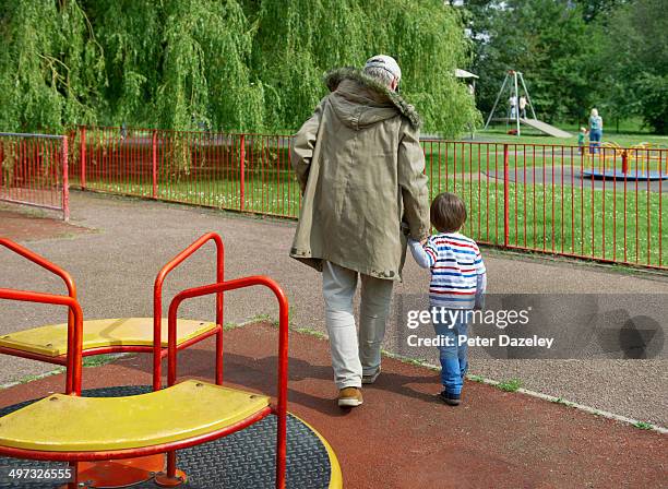 stranger leading child out of playground - peter parks fotografías e imágenes de stock