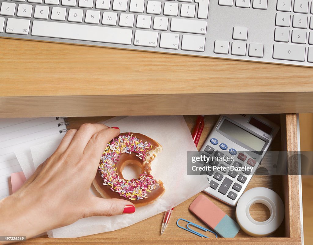Binge eater hiding doughnut in desk drawer