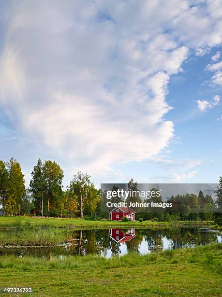 wooden house reflecting in water, vastergotland, sweden - schweden stock-fotos und bilder