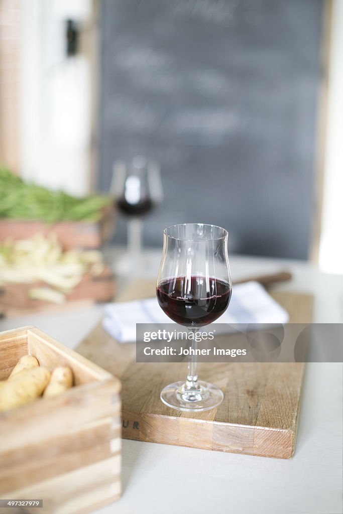 Wineglass with red wine on cutting board