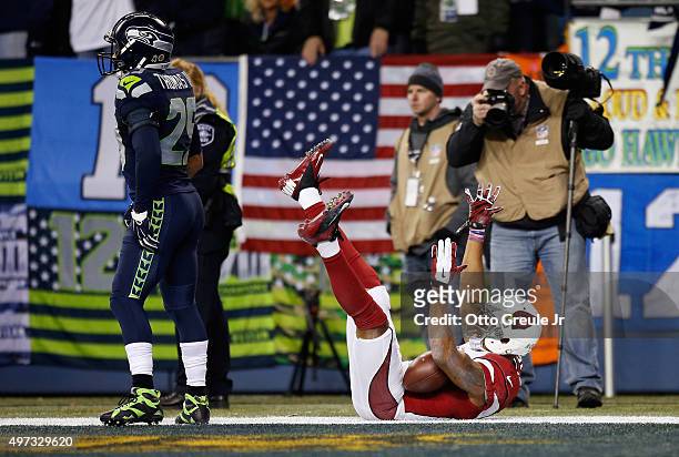 Michael Floyd of the Arizona Cardinals celebrates scoring a touchdown during the second quarter as Earl Thomas of the Seattle Seahawks looks on at...