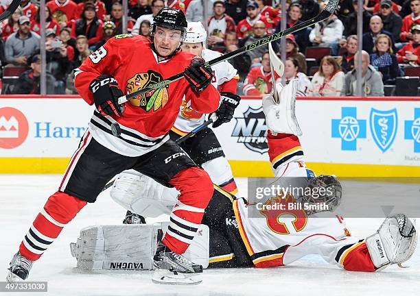 Ryan Garbutt of the Chicago Blackhawks watches the puck fly through the air, as goalie Karri Ramo of the Calgary Flames lays on the ice, in the third...