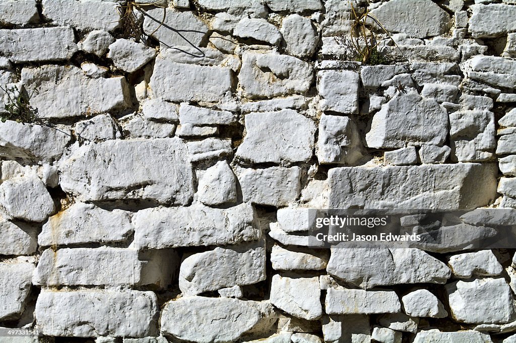 Hand-cut stones painted white form a wall in a Buddhist monastery.