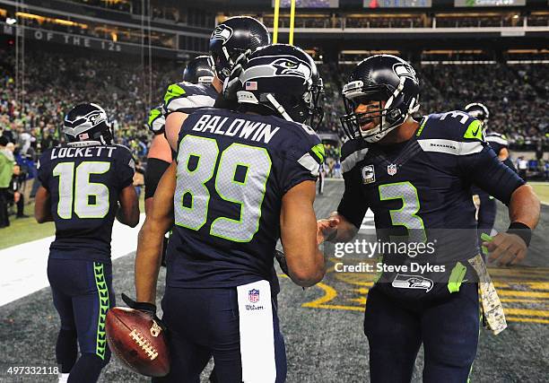 Doug Baldwin celebrates with Russell Wilson of the Seattle Seahawks in the end zone after scoring a touchdown during the third quarter against the...