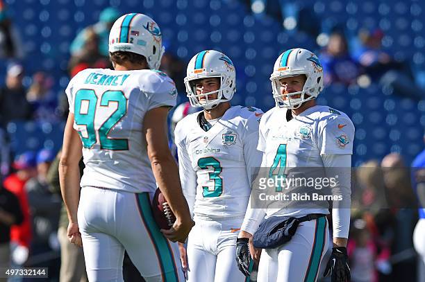 John Denney, Andrew Franks and Matt Darr of the Miami Dolphins talk prior to the game against the Buffalo Bills at Ralph Wilson Stadium on November...