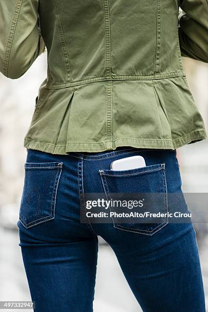 woman carrying smartphone in back pocket - phone in back pocket stock pictures, royalty-free photos & images