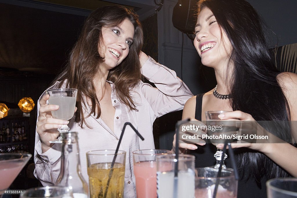 Women sharing laughs in nightclub