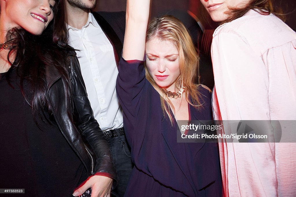 Young woman dancing with friends at night club