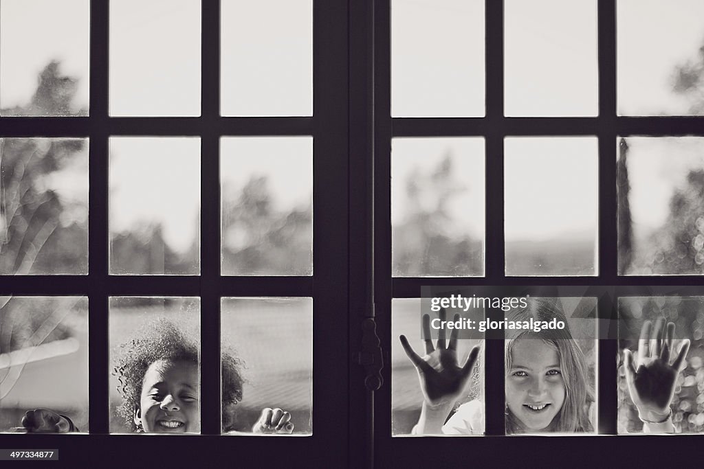 Two girls looking through a window