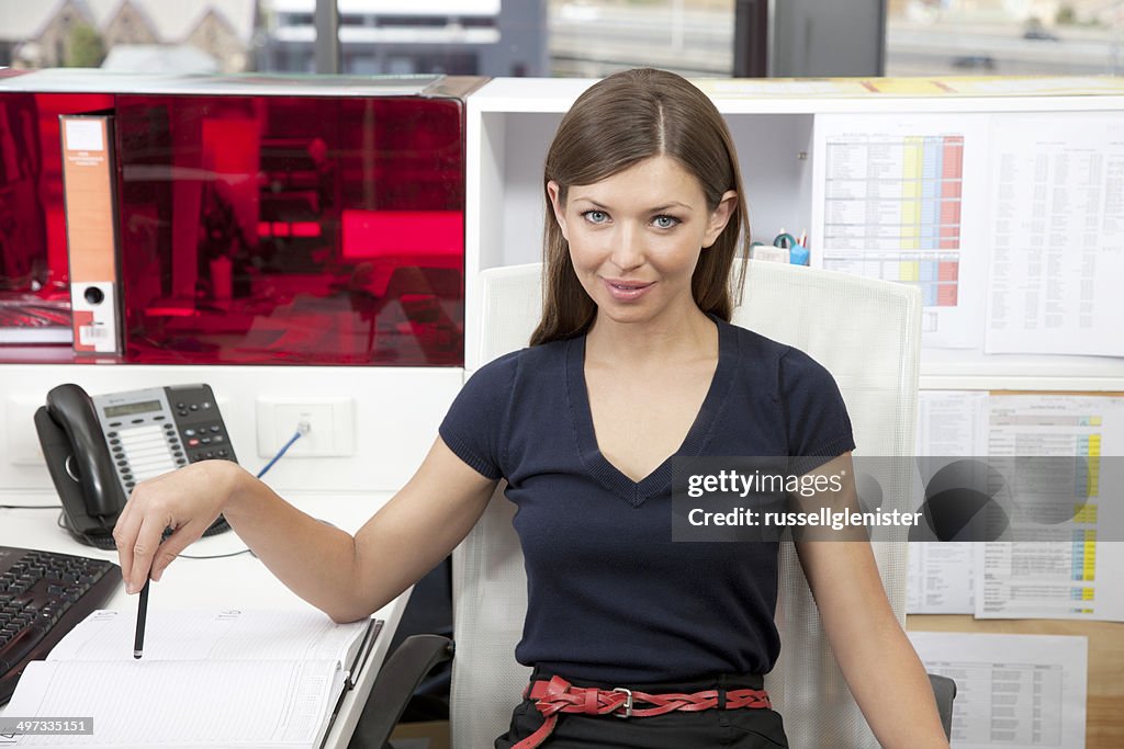 Portrait of young businesswoman at desk in office