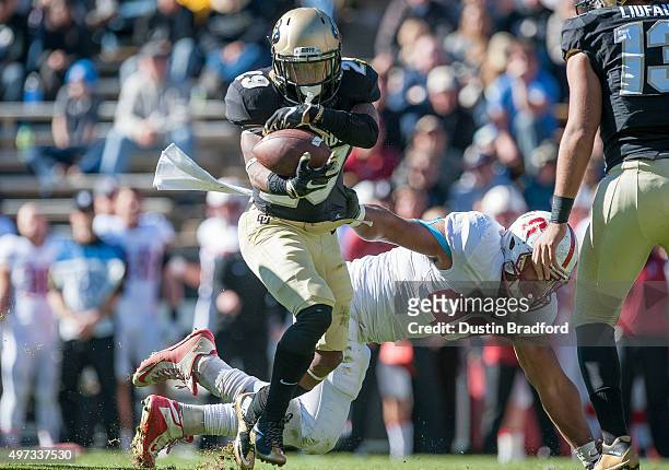 Wide receiver Donovan Lee of the Colorado Buffaloes is tackled for a loss by defensive end Solomon Thomas of the Stanford Cardinal at Folsom Field on...