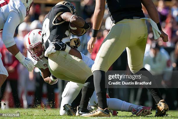 Wide receiver Donovan Lee of the Colorado Buffaloes is tackled for a loss by defensive end Solomon Thomas of the Stanford Cardinal at Folsom Field on...