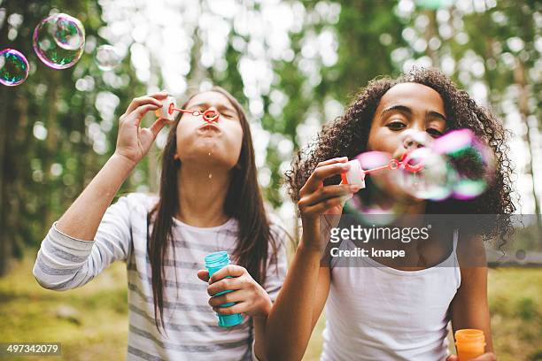 adorabile bambina soffiare le bolle d'aria aperta - bubble wand foto e immagini stock