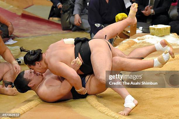 Mongolian yokozuna Harumafuji throws Ikioi to win during day nine of the Grand Sumo Kyushu Tounament at Fukuoka Convention Center on November 16,...