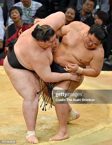 Mongolian wrestler Ichinojo pushes Myogiryu out of the ring to win during day nine of the Grand Sumo Kyushu Tounament at Fukuoka Convention Center on...