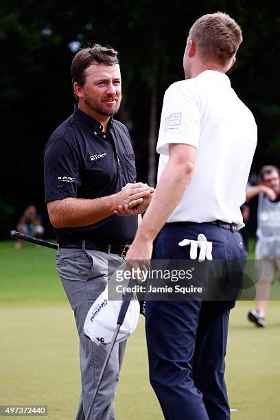 Russell Knox of Scotland congratulates Graeme McDowell of Northern Ireland on the 18th hole after winning the three man playoff in the final round of...