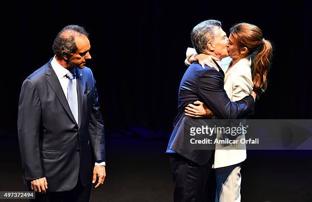 Mauricio Macri, Mayor of Buenos Aires and presidential candidate for CAMBIEMOS and his wife Juliana Awada kiss each other as Daniel Scioli, Governor...