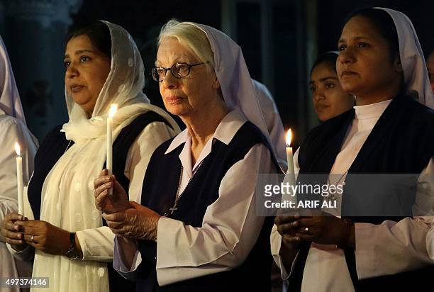 Pakistani Christians hold candles in tribute to victims of the November 13 Paris attacks, at a church in Lahore on November 16, 2015. Islamic State...