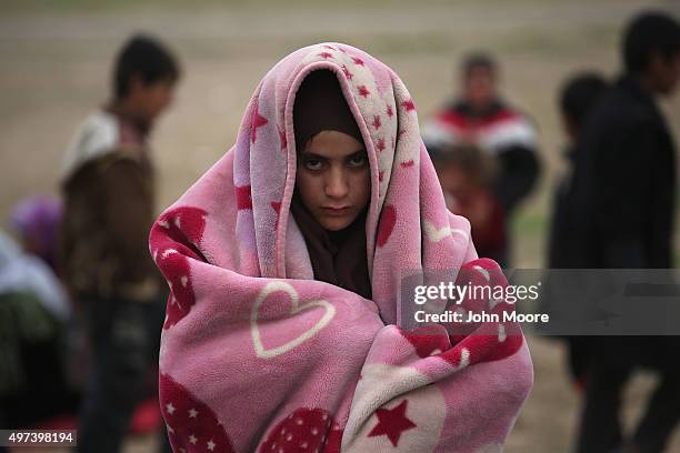 Girl bundles against the cold while fleeing an ISIL or Daesh-held frontline village on November 16, 2015 to Sinjar, Iraq. Peshmerga forces carefully...