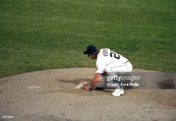 Mark Fidrych of the Detroit Tigers scoops up dirt after the last game played at the Tiger Stadium against the Kansas City Royals in Detroit,...