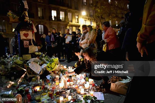 Members of the public view candles and tributes left opposite the main entrance of Bataclan concert hall as French police lift the cordon following...