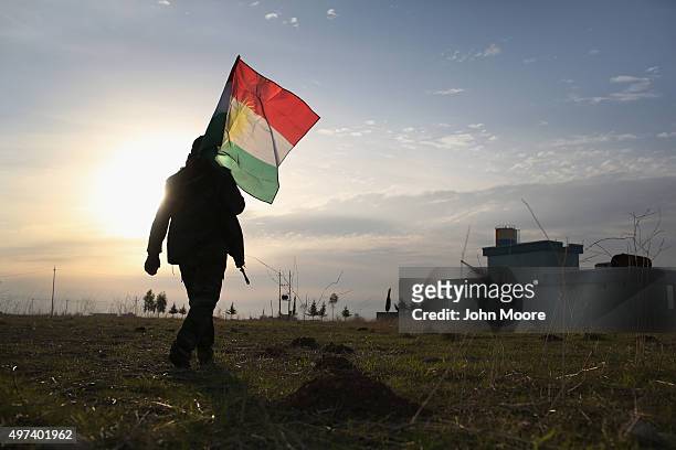 Peshmerga soldier walk to place a Kurdish flag near the frontline with ISIL on November 16, 2015 in Sinjar, Iraq. Kurdish forces, with the aid of...
