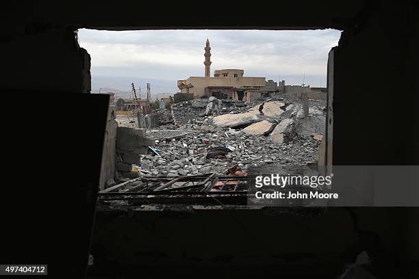 Kurdish Peshmerga soldier searches for weapons in the rubble of an airstrike near a mosque on November 16, 2015 in Sinjar, Iraq. Kurdish forces, with...