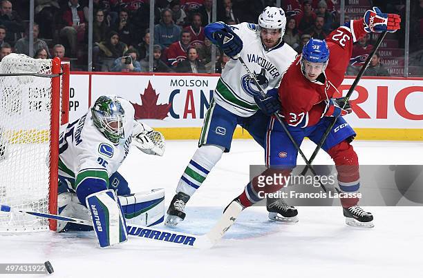 Jacob Markstrom and Matt Bartkowski of the Vancouver Canucks defend the goal against Brian Flynn of the Montreal Canadiens in the NHL game at the...