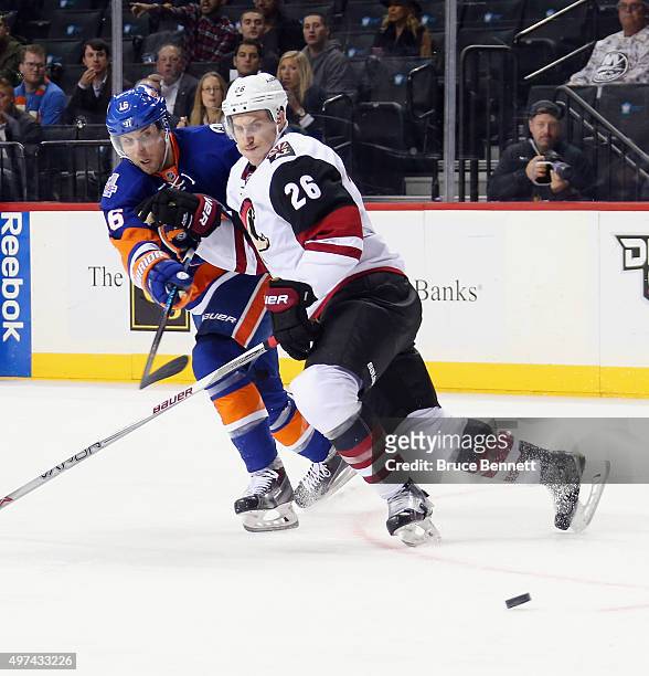 Michael Stone of the Arizona Coyotes checks Steve Bernier of the New York Islanders during the second period at the Barclays Center on November 16,...