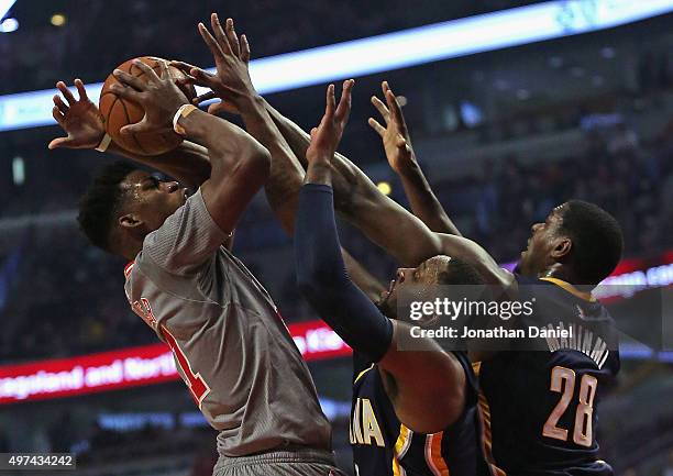 Jimmy Butler of the Chicago Bulls tries to get off a shot under pressure from C.J. Miles and Ian Mahinmi of the Indiana Pacers at the United Center...