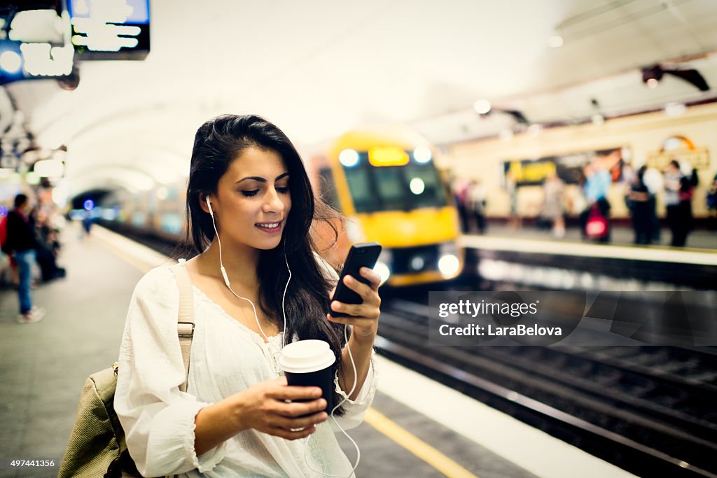 Young woman using a phone at train station in Sydney