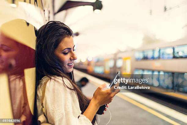 young woman using a phone at train station in sydney - sydney train stock pictures, royalty-free photos & images