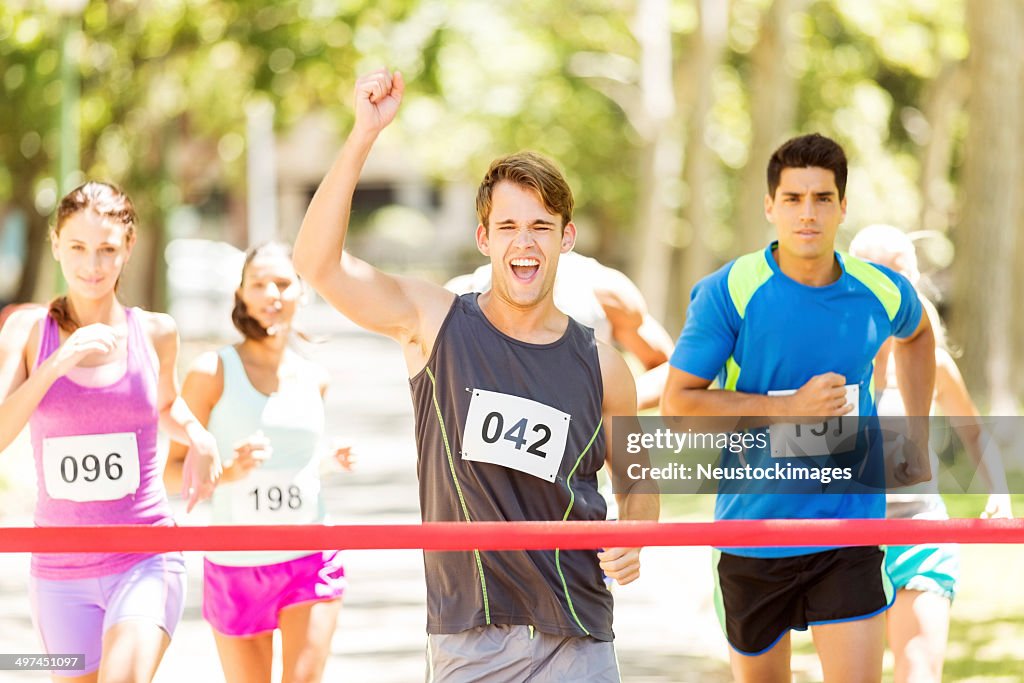 Entusiasta uomo incrocio traguardo di una maratona