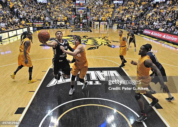 Guard Aaron Wheler of the Charleston Southern Buccaneers drives to the basket against guard Evan Wessel of the Wichita State Shockers during the...