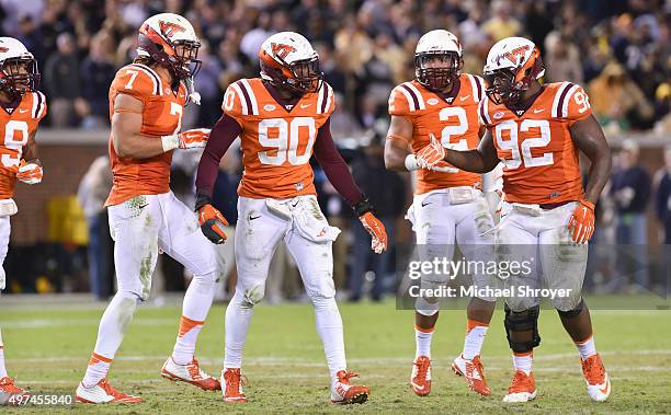 Defensive tackle Luther Maddy, defensive end Dadi Nicolas, and tight end Bucky Hodges of the Virginia Tech Hokies react following a fumble recovery...